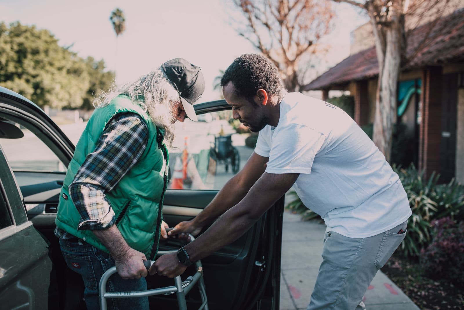 Volunteer gently helping an elderly neighbor with dignity and care