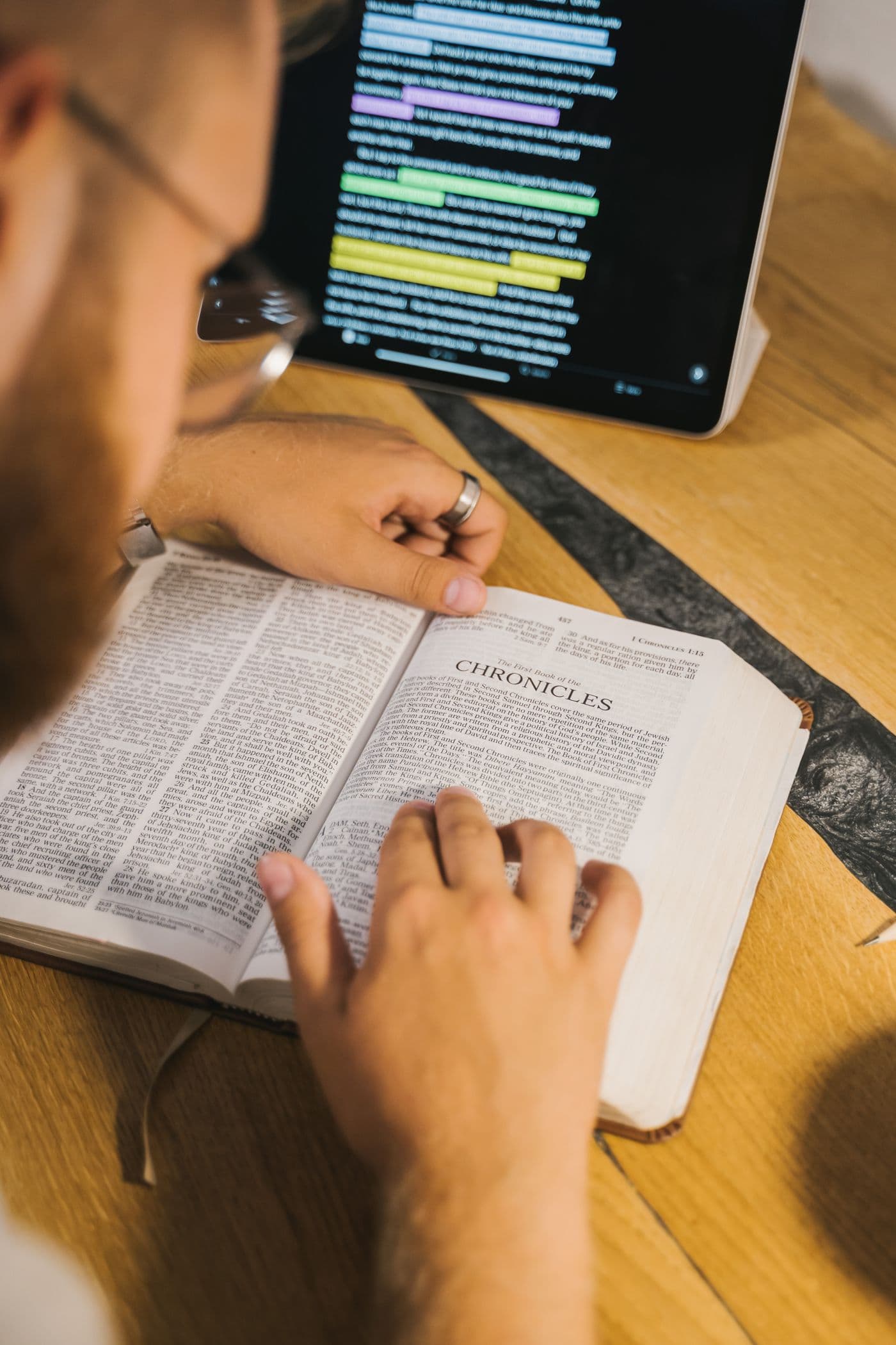 Open Bible beside a tablet with highlighted Scripture — preparing Gospel content for digital platforms